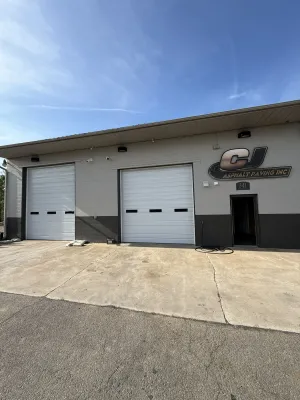 Two white ribbed commercial steel garage doors on industrial building
